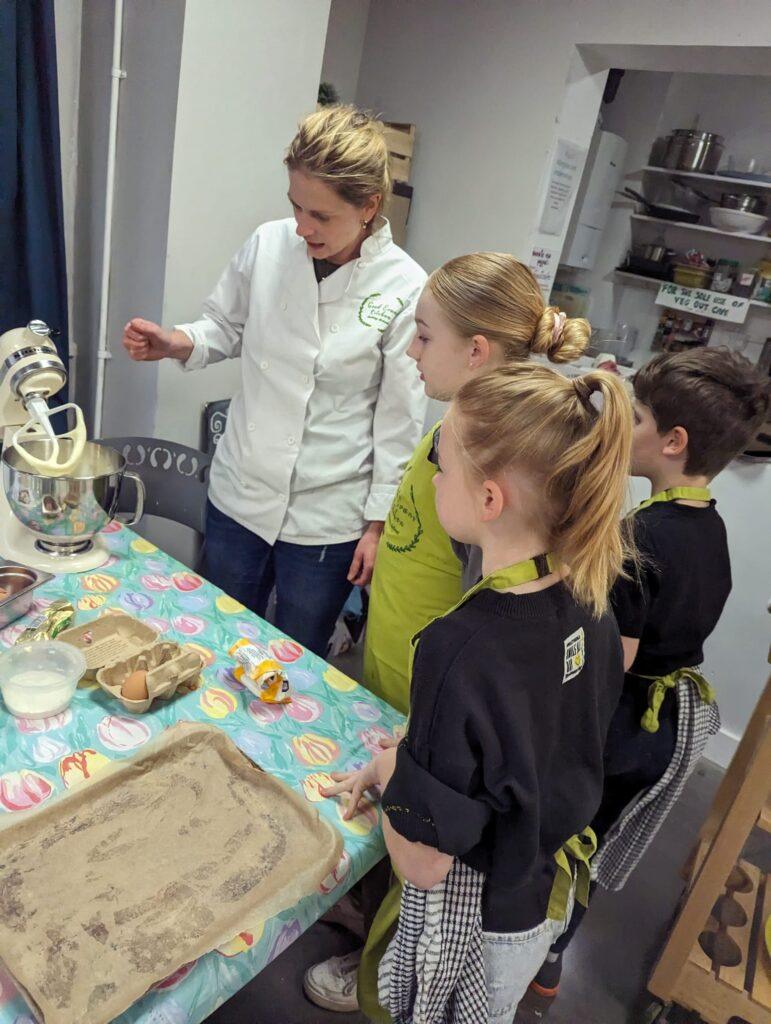 Katie teaching a group of children to cook at a family workshop