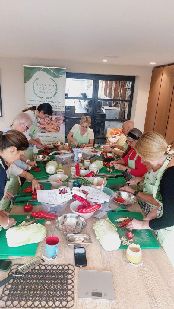 Children and adults cooking together around a long table at a family workshop